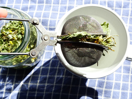 self-dried herbal tea of chamomile, lemon balm and mint in a glass jar, with a tea egg filled with...