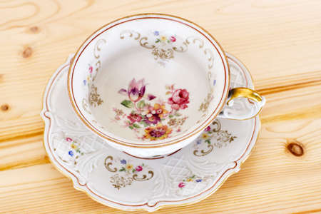 Antique floral cup on the wooden surfaceの写真素材