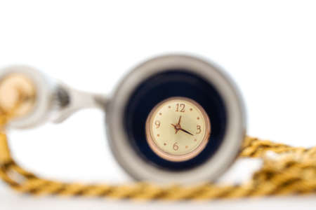 golden woman's wrist-watch through opera glasses on white backgroundの写真素材