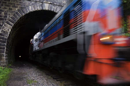 Locomotive driving out from tunnel. Old, long (0.78 km) and straight railroad tunnel of the...