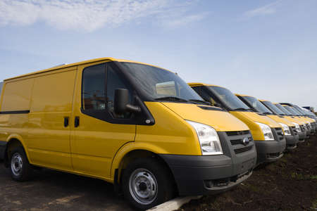 Row of yellow blank delivery vans or trucksの写真素材