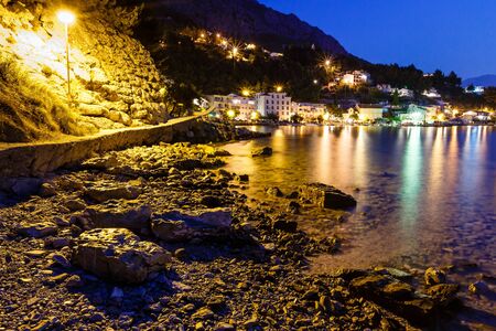 Illuminated Rocky Beach and Transparent Mediterranean Sea in the Night, Croatiaの写真素材