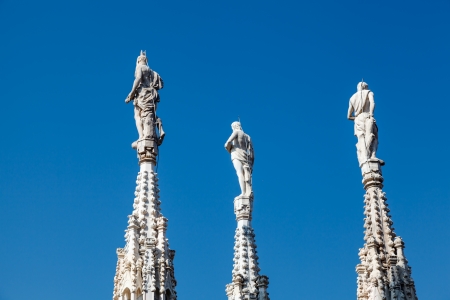 Three Sculptures on the Roof of Milan Cathedral, Lombardy, Italyの写真素材