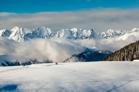 Panoramic View on Mountains and Two People Walking in French Alps in Winterの写真素材