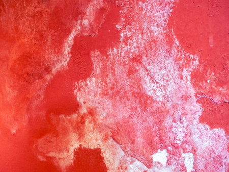 a red wall with a rough white abstract texture due to continuous exposure to waterの写真素材
