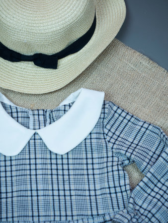 Straw hat and shirt on the gray background. Close-up.