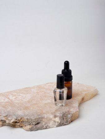 Essential oil in a glass bottle with pipette on stone backgroundの写真素材