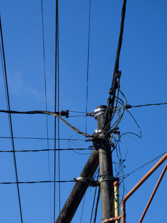 electricity post with blue sky in the background, closeup of photo detail a series of electric...