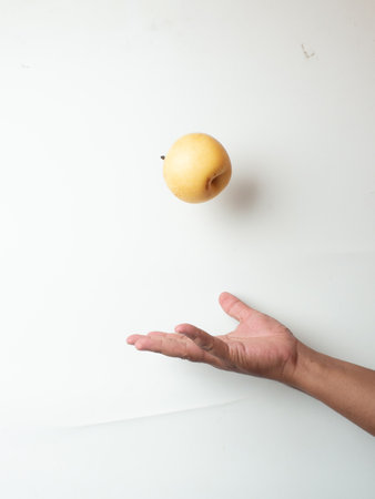 Hand holding an apple on a white background with copy space for text