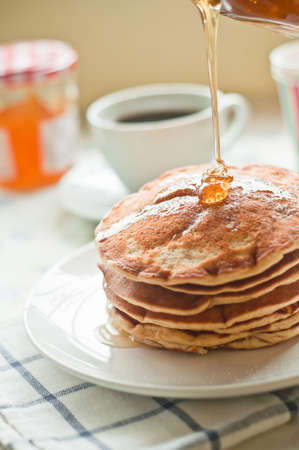 Honey Pouring over fresh pancakes の写真素材