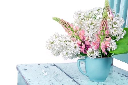 Arrangement of wildflowers on a rustic light blue chair isolated on whiteの写真素材