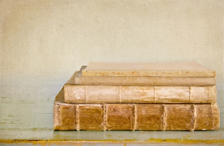 Ancient old books on a wooden table with textured editingの写真素材