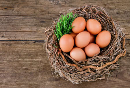 Eggs and rosemary leaves in a basket on a wooden rustic backgroundの写真素材
