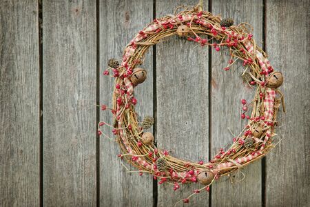 Christmas wreath hanging on a wooden rustic vintage background with copy spaceの写真素材