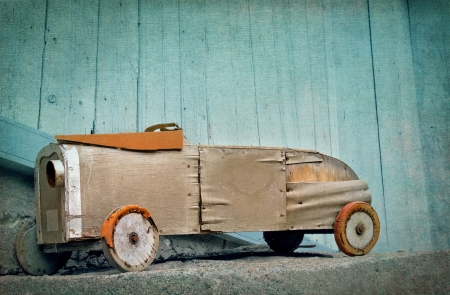 Old wooden rustic toy car on a light blue textured artistic backgroundの写真素材