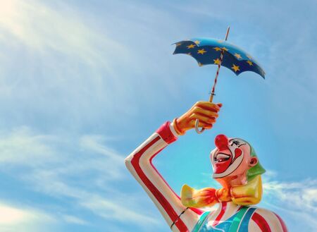 Closeup of a carnival clown statue with blue sky background and copy spaceの写真素材
