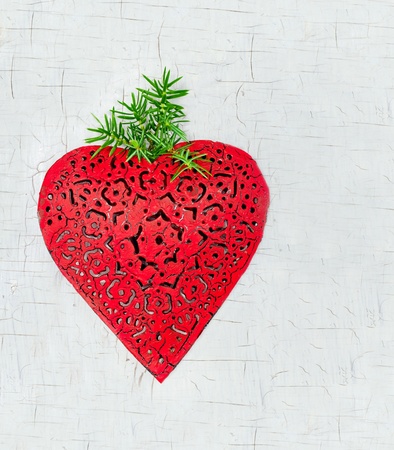 Red heart shaped Christmas decoration on white wooden rustic backgroundの写真素材