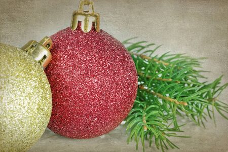 Red and golden Christmas baubles with pine /spruce tree branch on rustic backgroundの写真素材