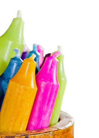 Collection of colorful tall candles isolated on white stored in a wooden vaseの写真素材