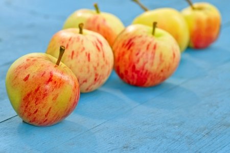 Red apples on a blue rustic wooden backgroundの写真素材