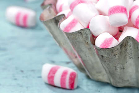 Peppermint sweets in a rustic cupcake bowl with shabby chic wooden background