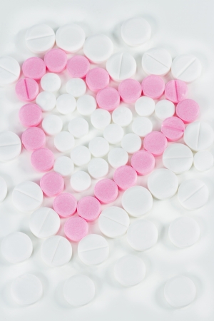 Pink medicine pills shaped as a heartの写真素材