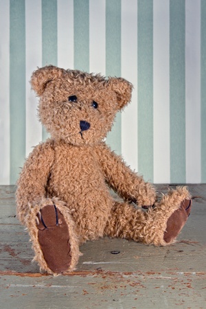 Old vintage teddy bear on green wooden rustic backgroundの写真素材