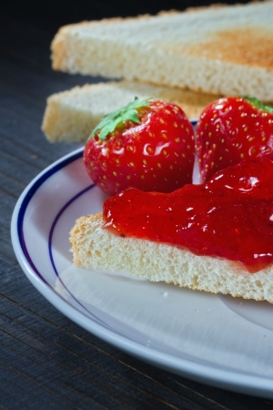 Toast with strawberry jelly on black wooden rustic backgroundの写真素材