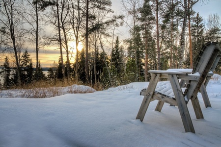 View at wintry landscape with two empty chairs covered with snowの写真素材