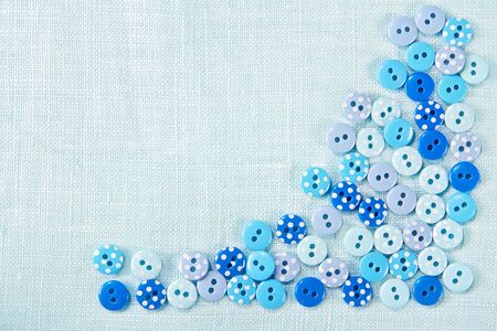 Blue decorative buttons on linen with copy space - sewing background