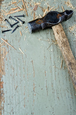 Old vintage hammer and black nails on green rustic wooden background with copy space, diy conceptの写真素材