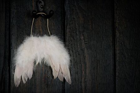 Feathered angel wings on dark wooden rustic backgroundの写真素材