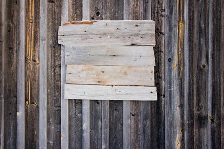 Wooden old bulletin board nailed to wooden exterior wall, empty for copy spaceの写真素材