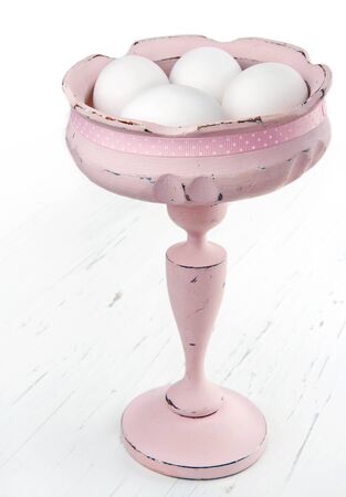 Elegant easter decoration, white eggs in a pink shabby chic vintage wooden bowlの写真素材