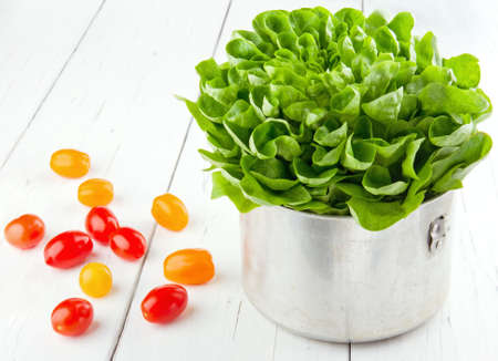 Fresh tomatos and green salad on white wooden table - healthy eating conceptの写真素材