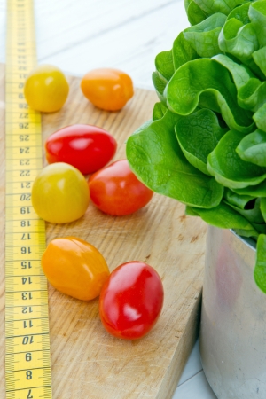 Tomatos, salad and measurement tape - diet and healthy eating; weight loss conceptの写真素材