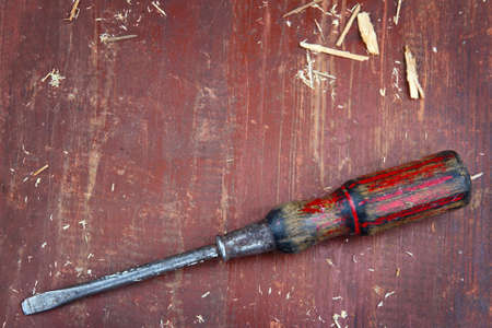Old screwdriver on old red wooden background - DIY concept