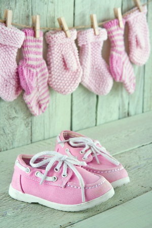 Pink toddler shoes on wooden light green vintage backgroundの写真素材