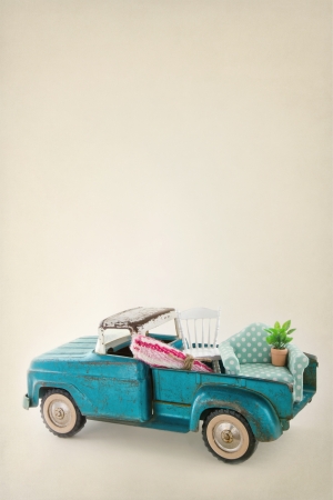 Old vintage toy truck packed with furniture - moving houses concept and copy spaceの写真素材