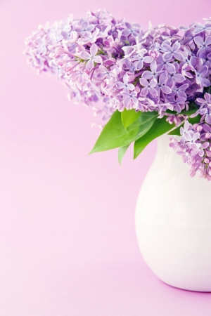 White vase with a bouquet of purple lilac spring flowersの写真素材