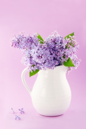 White vase with a bouquet of purple lilac spring flowersの写真素材