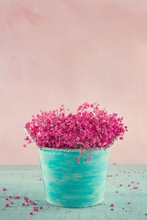Pink dried baby's breath flowers in a blue vase on wooden vintage backgroundの写真素材