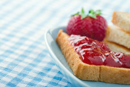 Slices of toast with red strawberry jam and fresh berries on blue vintage backgroundの写真素材