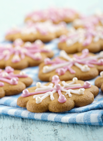 Christmas gingerbread cookies with pink frosting on pastel blue vintage wooden backgroundの写真素材