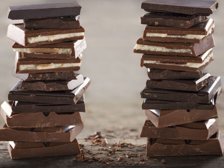 Piles of chocolate on wooden rustic bakcgroundの写真素材