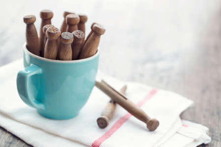Wooden clothespins in a blue cup and white clean towel with vintage editing - housework conceptの写真素材
