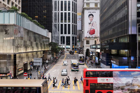 Hong Kong, China- March 04 2019: Pedestrians cross Pedder Street by a Louis Vuitton store in...