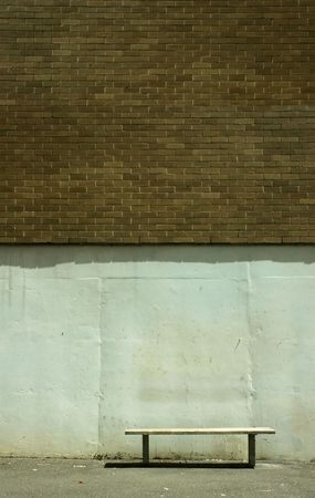 a Bench under a golden colour brick wall