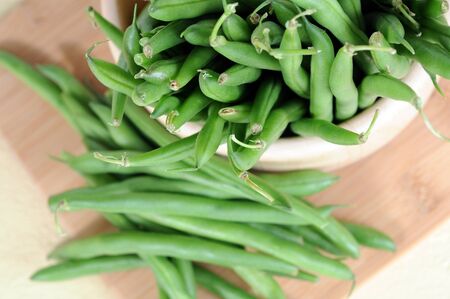 green beans in bowl on wooden cutting boardの写真素材