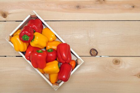 mini bell peppers in wooden crateの写真素材